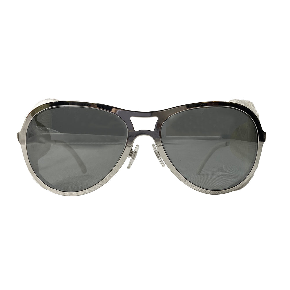 Very rare Chanel chrome and faux fur sunglasses by Karl Lagerfeld for Chanel  with oversized frames and Chanel engraved on side arms, dark gray lenses. Removable white faux fur side panel “blinders" with cream leather appliqué interlocking CC logo.  Model: 40852A Chanel case included. Made in Italy 