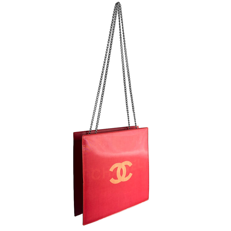 Chanel rectangular vinyl shoulder bag by Karl Lagerfeld for Chanel, 2000 with silver-tone double chain shoulder strap and lenticular/holograph design that flip flops between gold-tone interlocking CC logo and CHANEL Paris. Open top with vinyl interior and one zippered pocket. Made in France 