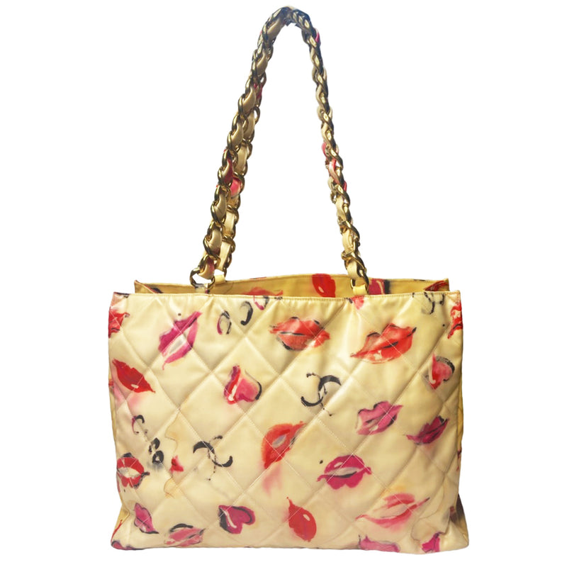 Chanel 1995 cream with printed red lips and hearts vinyl tote by Karl Lagerfeld for Chanel, double chain shoulder straps, oversized white interlocking front CC vinyl appliqué. Open top with interior cream color grosgrain lining, zippered pocket with gold-tone CC logo zipper pull, large slip pocket. Made in Italy 