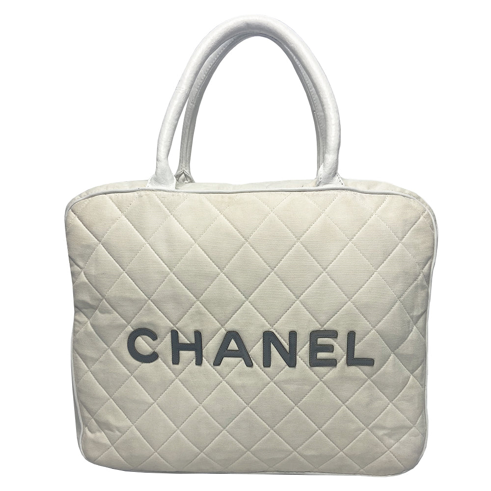 Chanel Logo white canvas quilted bowler by Karl Lagerfeld for Chanel 2001 with rolled leather handles, leather piping and grey leather, front CHANEL logo letters. Silver-tone top zip closure with CC logo grey rubber zipper pulls, Chanel logo rubber protective feet. White textile lining, one open leather pocket. Made in Italy