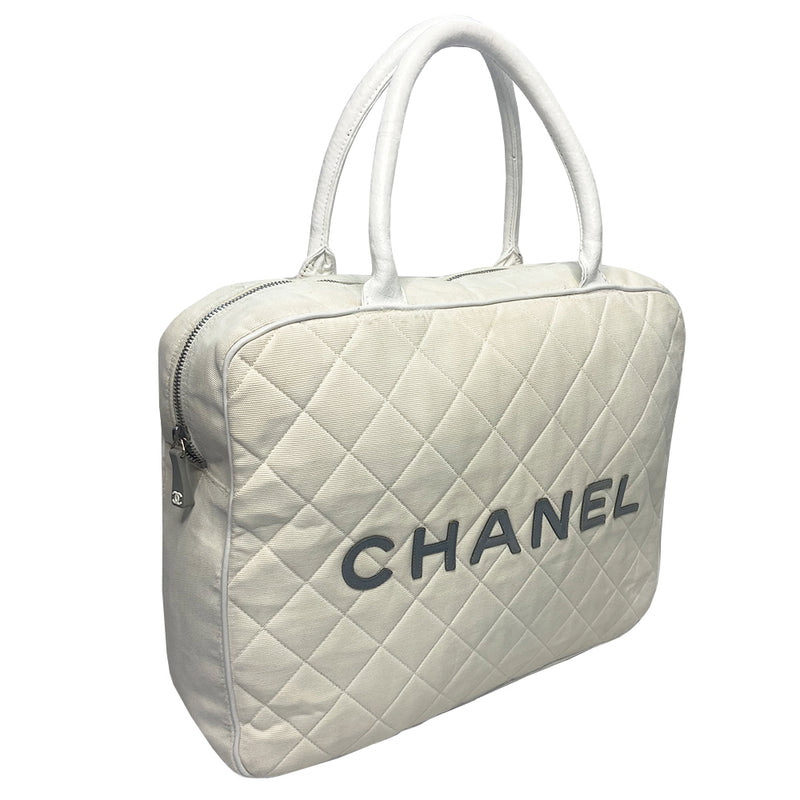 Chanel Logo white canvas quilted bowler by Karl Lagerfeld for Chanel 2001 with rolled leather handles, leather piping and grey leather, front CHANEL logo letters. Silver-tone top zip closure with CC logo grey rubber zipper pulls, Chanel logo rubber protective feet. White textile lining, one open leather pocket. Made in Italy