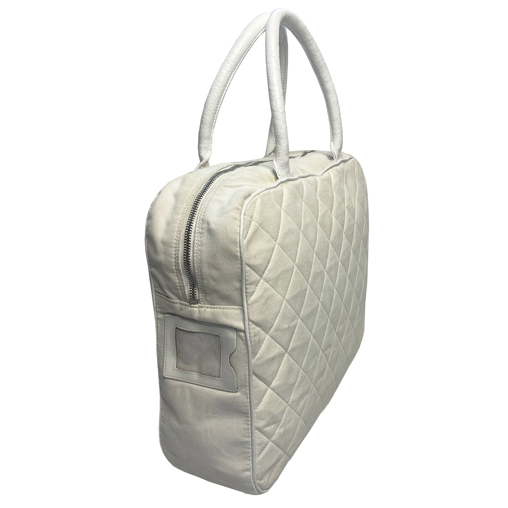 Chanel Logo white canvas quilted bowler by Karl Lagerfeld for Chanel 2001 with rolled leather handles, leather piping and grey leather, front CHANEL logo letters. Silver-tone top zip closure with CC logo grey rubber zipper pulls, Chanel logo rubber protective feet. White textile lining, one open leather pocket. Made in Italy