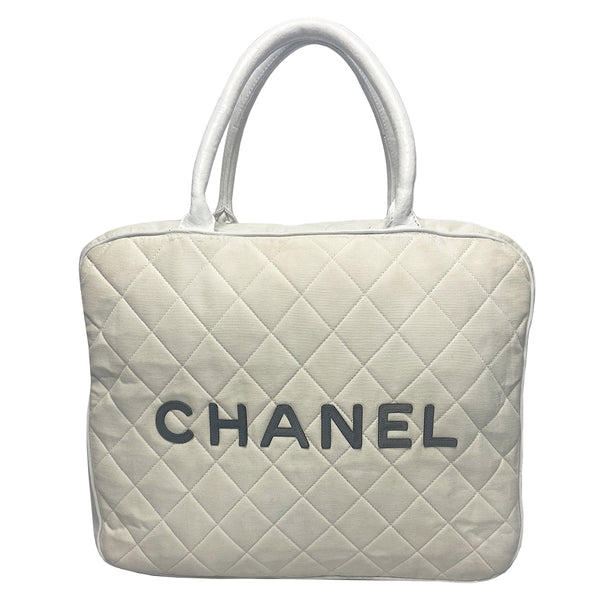 Chanel Logo white canvas quilted bowler by Karl Lagerfeld for Chanel 2001 with rolled leather handles, leather piping and grey leather, front CHANEL logo letters. Silver-tone top zip closure with CC logo grey rubber zipper pulls, Chanel logo rubber protective feet. White textile lining, one open leather pocket. Made in Italy