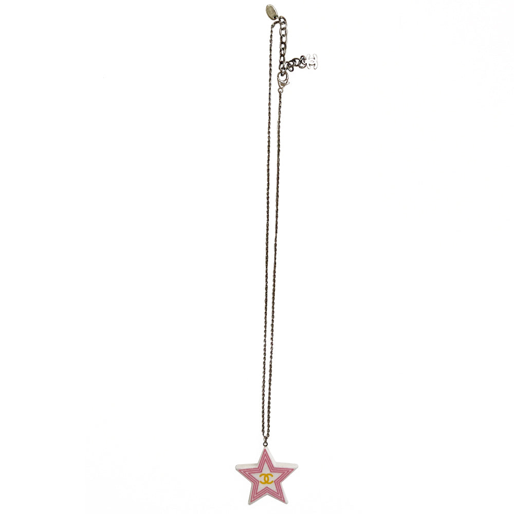 Chanel 2 sided white resin star pendant necklace by Karl Lagerfeld for Chanel Cruise collection, 2004 with pink border and yellow CC logo on one side, green logo on the other. Silver-tone long chain with lobster closure, interlocking metal CC logo charm at one end and metal stamped tag attached. Made in France.