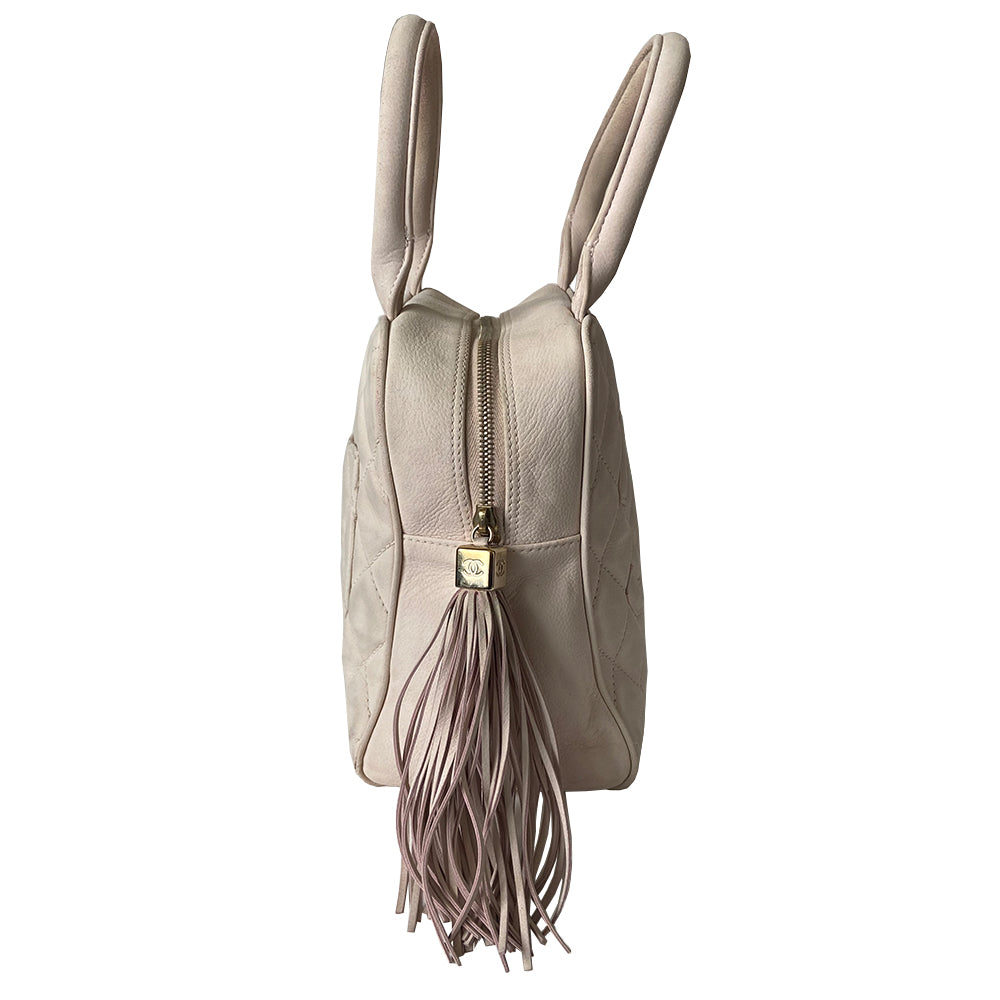 Chanel powder pink Mini Tassel Boston bag by Karl Lagerfeld for Chanel 2004. Rectangle suede quilted bowler bag with CC front logo and 2 rolled top handles, gold-tone feet on bottom. Top zipper closure with gold logo cube and tassel zipper pull, pink Chanel print lining, zip pocket. Outer rear slip pocket. Made in France 