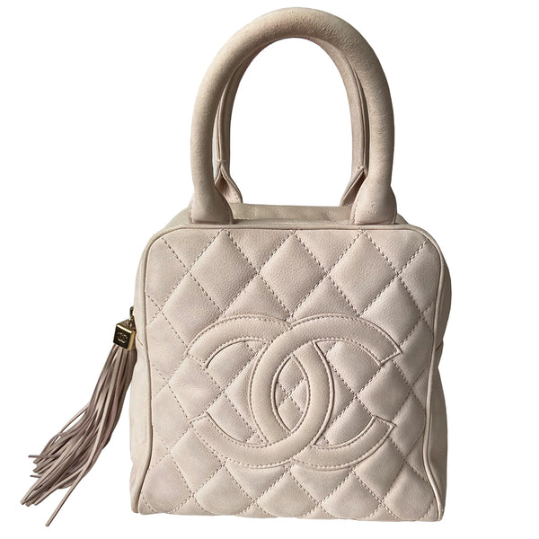 Chanel powder pink Mini Tassel Boston bag by Karl Lagerfeld for Chanel 2004. Rectangle suede quilted bowler bag with CC front logo and 2 rolled top handles, gold-tone feet on bottom. Top zipper closure with gold logo cube and tassel zipper pull, pink Chanel print lining, zip pocket. Outer rear slip pocket. Made in France 