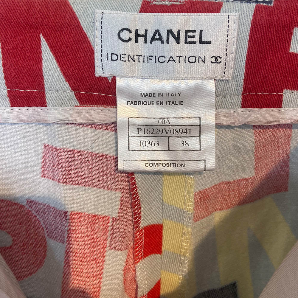 Chanel Identification Collection high rise graphic letters denim pants from Karl Lagerfeld for Chanel, 2000 with panel details at back hemline, zip fly with hook closure, bold all over colorful lettering spell out CHANEL, COCO, PARIS. Striped knit accent at front pockets and bottom hem. Made in Italy 