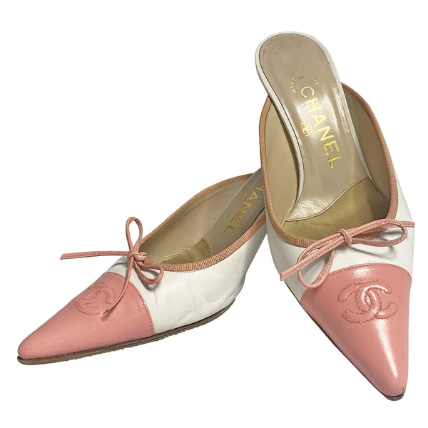 Chanel CC logo cap toe mules by Karl Lagerfeld for Chanel circa early 2000’s. White leather with pink pointed toe cap featuring tonal stitched interlocking CC logo with pink grosgrain edging and pink leather front bow. Leather upper, heels and sole. Made in Italy 