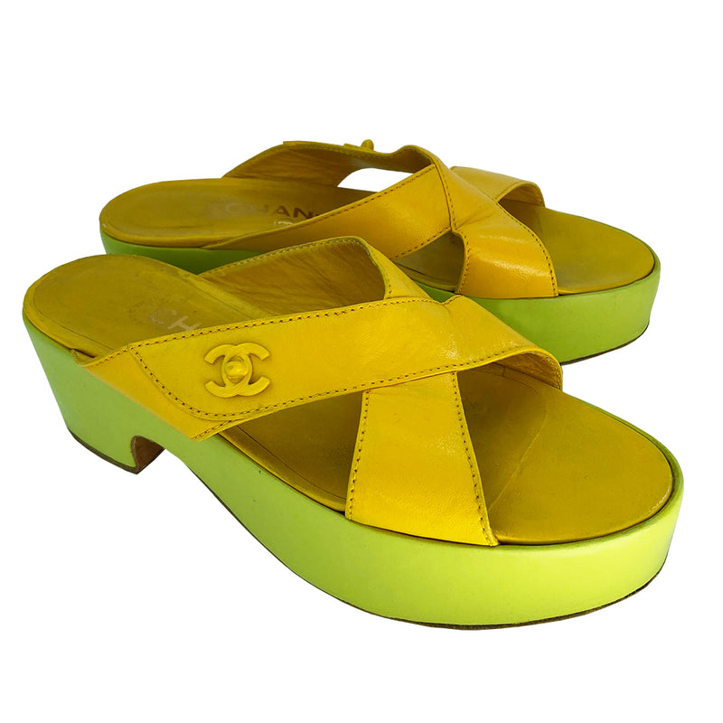 Chanel Lemon-Lime two tone lamb leather platform open toe slip on sandals circa 2002.  2” platform with small heel. Bright yellow criss-cross upper with tonal accent stitching and signature Mademoiselle lock adornment and lime green platform. Size: IT 38 Some visible scuffing. Made in Italy 