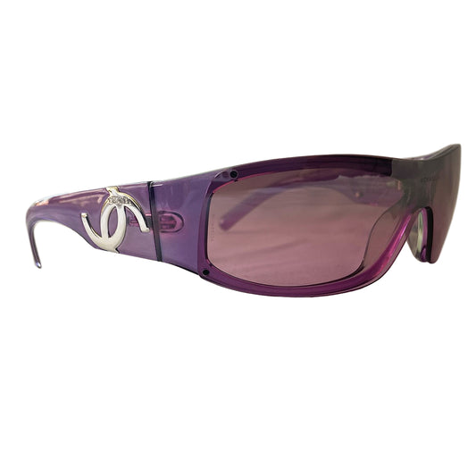 Chanel purple wrap CC logo sunglasses by Karl Lagerfeld for Chanel with frameless lens with wide purple arms and silver-tone asymmetric CC logo at temples. Style: 5072  Made in Italy 