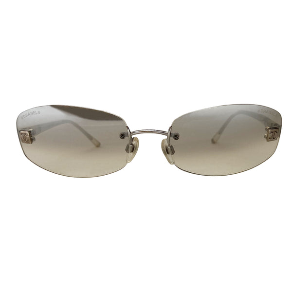 Chanel gradient lens frameless CC logo sunglasses with rounded rectangular shaped rimless lenses and silver-tone boxed CC logo in silver on each lens. Slightly mirrored smoke to clear gradient lenses and silver-tone metal arms covered with clear plastic. Style: 4067 c 124/61. Made in Italy