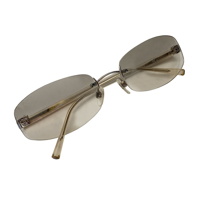 Chanel gradient lens frameless CC logo sunglasses with rounded rectangular shaped rimless lenses and silver-tone boxed CC logo in silver on each lens. Slightly mirrored smoke to clear gradient lenses and silver-tone metal arms covered with clear plastic. Style: 4067 c 124/61. Made in Italy
