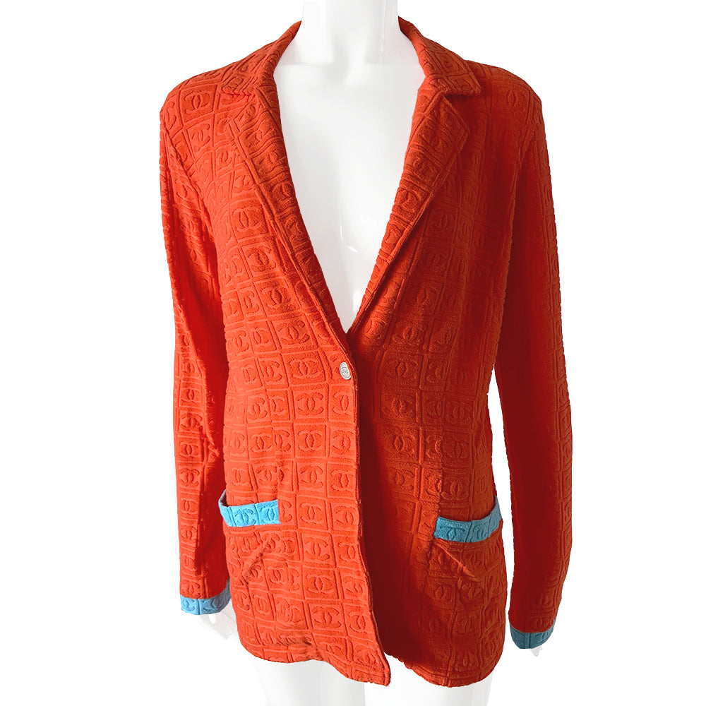 Chanel monogram terrycloth blazer by Karl Lagerfeld for Chanel S/S 2002 with long sleeves, all over boxed CC logo pattern, notched lapel, single logo silver-tone front snap button closure and 2 front patch pockets. Tangerine orange with turquoise accent.  Made in France 