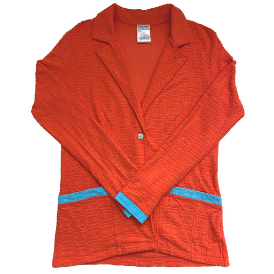 Chanel monogram terrycloth blazer by Karl Lagerfeld for Chanel S/S 2002 with long sleeves, all over boxed CC logo pattern, notched lapel, single logo silver-tone front snap button closure and 2 front patch pockets. Tangerine orange with turquoise accent.  Made in France 
