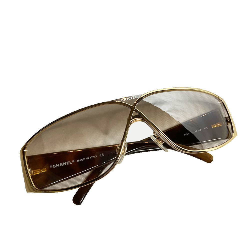 Chanel gold-tone metal frame and thick quilted acetate arms sunglasses by Karl Lagerfeld for Chanel, Infinity shaped design metal frame over shield lens, CHANEL printed on lens at nose bridge with booze lens Style: 4097 Made in Italy