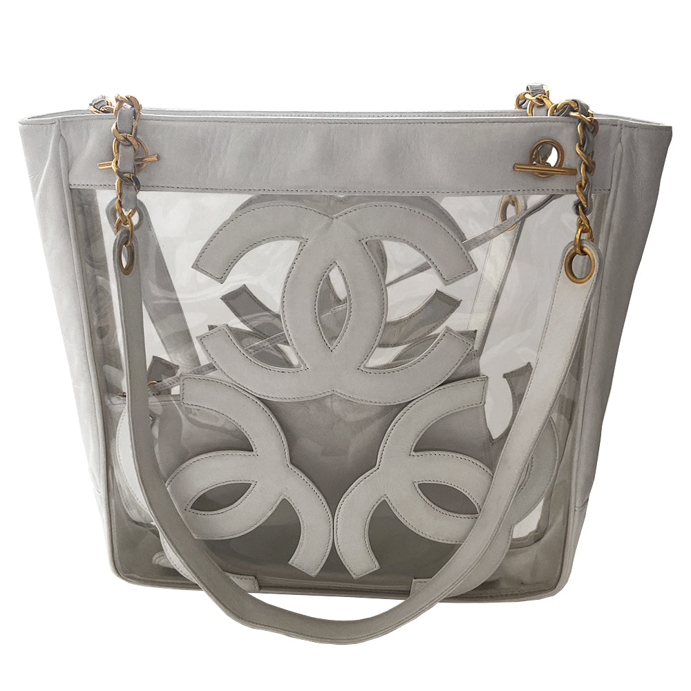 Chanel Triple CC tote by Karl Lagerfeld for Chanel, 1995. Clear vinyl with white lamb leather CC logos, outer edges, leather with gold chain shoulder straps, interior dual gold Chanel engraved magnetic snap closure. Attached leather inner zippered pouch with gold-tone CC logo zipper pull. Interior date code attached. Made in Italy 