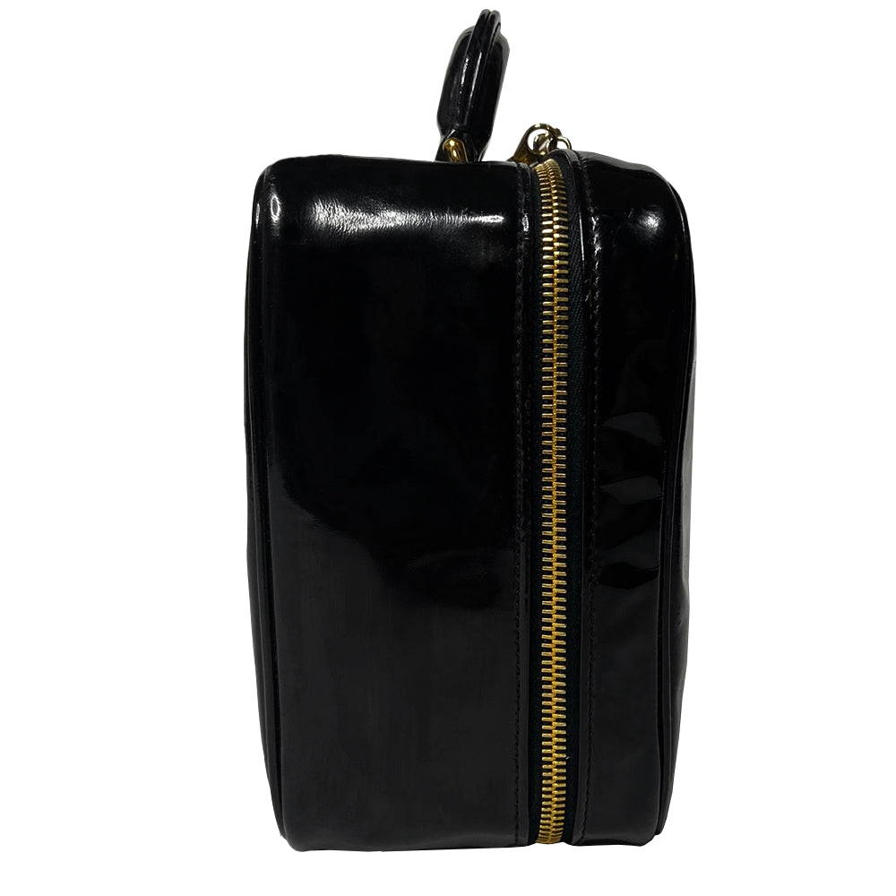 Chanel patent leather vanity case by Karl Lagerfeld for Chanel 1996 with interlocking CC logo at front, dual logo zipper pull closure, top carry handle and removable long strap. Leather interior with inner flap that snaps to side, zippered pocket with logo zipper pull, serial number sticker attached. Made in Italy