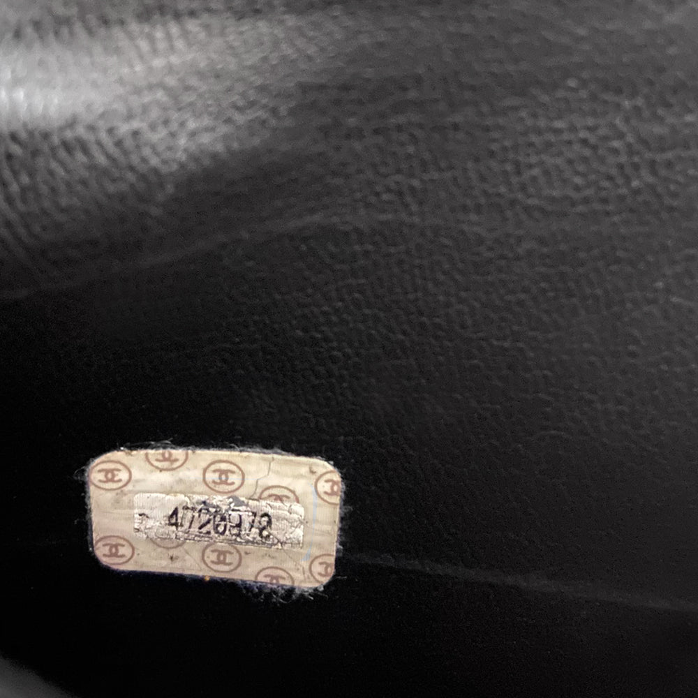 Chanel patent leather vanity case by Karl Lagerfeld for Chanel 1996 with interlocking CC logo at front, dual logo zipper pull closure, top carry handle and removable long strap. Leather interior with inner flap that snaps to side, zippered pocket with logo zipper pull, serial number sticker attached. Made in Italy