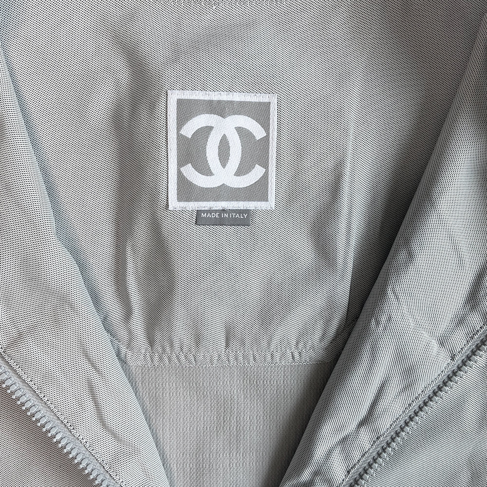 Chanel Identification logo collarless zip front grey vest/top by Karl Lagerfeld for Chanel, spring 2001 with box CC logo appliqué in back, CC logo engraved zipper pull and silver-tone toggles that adjust the elastic cording at bottom hemline. Made in Italy 