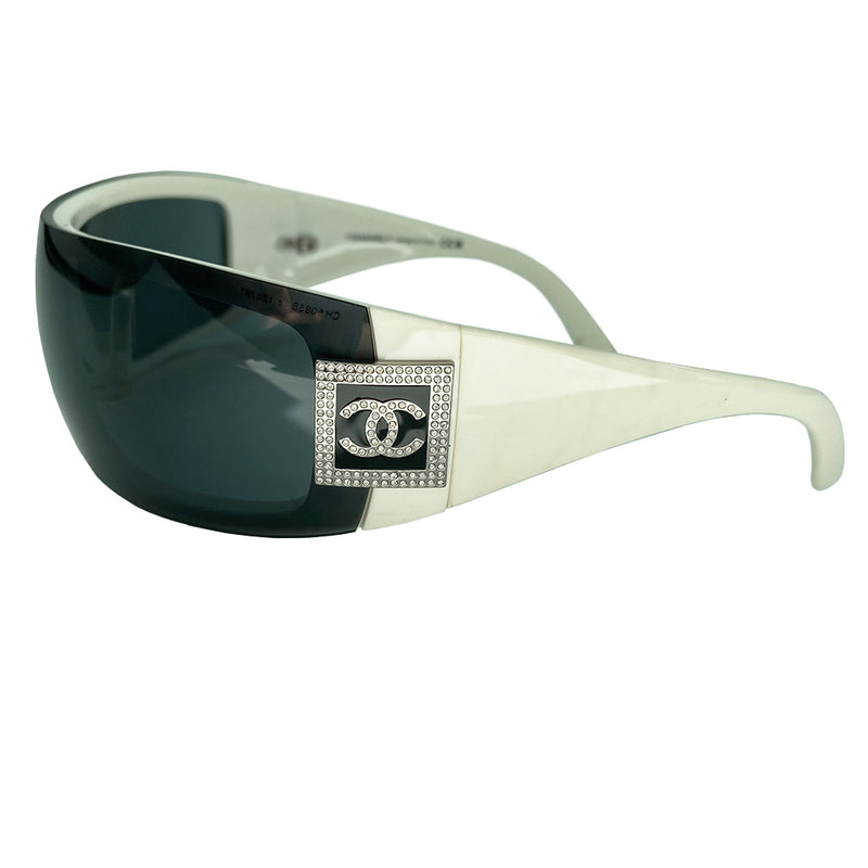Chanel crystal embellished black and white wrap logo shield sunglasses circa mid 2000’s with removable gradient smoke color lens and crystal box CC logo at temples. Style: 5085 Faint scratching on lenses; doesn't impede vision. Made in Italy Lens Width approx (in) 8.5" Lens Height (in) 2"