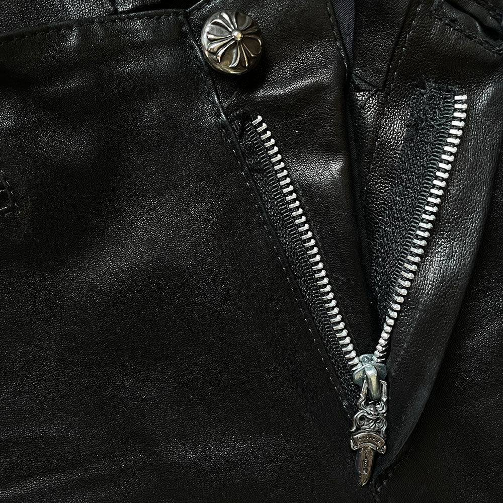 Butter soft women’s boot cut leather pants with CH appliqué signature fleur de lis at front knees. Faux front slash pockets, zip fly closure with signature dagger zipper pull and sterling cross top button. Chrome Hearts USA banner embossed leather patch at interior waist. Made in USA 