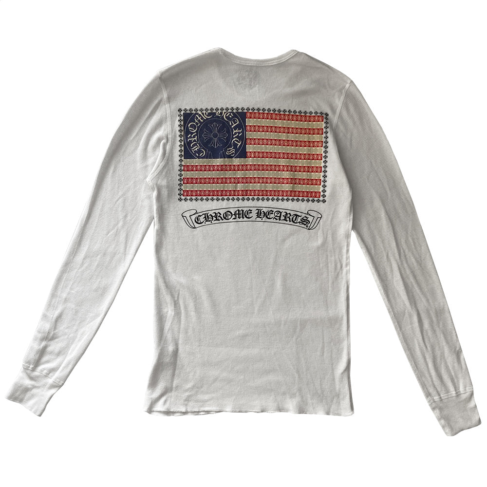 Chrome Hearts white cross thermal knit long sleeve tee with dagger design inside Chrome Hearts horseshoe logo at chest, CH at bottom front hemline, Chrome Hearts emblem and tiny daggers, red, white, blue American flag with surrounding crosses accent and logo scroll underneath. Made in USA