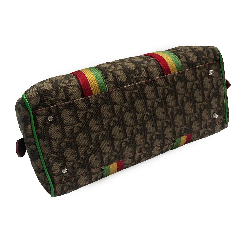 Christian Dior Rasta Boston Bag by John Galliano, 2003 beige and brown Diorissimo coated canvas, silver-tone hardware, vermillion leather rolled handles, yellow accent at base of handles. Yellow #1 front. Red, yellow and green canvas stripe on beige and brown Diorissimo print with bright green piping. Bottom domed silver-tone feet, single interior zip pocket and zip closure at top Vermillion textile interior, single zip pocket.