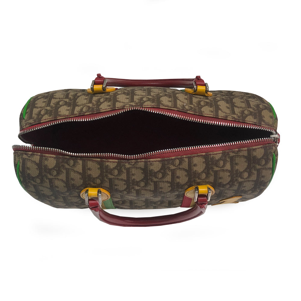 Christian Dior Rasta Boston Bag by John Galliano, 2003 beige and brown Diorissimo coated canvas, silver-tone hardware, vermillion leather rolled handles, yellow accent at base of handles. Yellow #1 front. Red, yellow and green canvas stripe on beige and brown Diorissimo print with bright green piping. Bottom domed silver-tone feet, single interior zip pocket and zip closure at top Vermillion textile interior, single zip pocket.