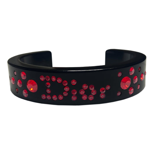 Christian Dior narrow black acrylic cuff with Dior spelled out in brilliant red crystals. with original box. 