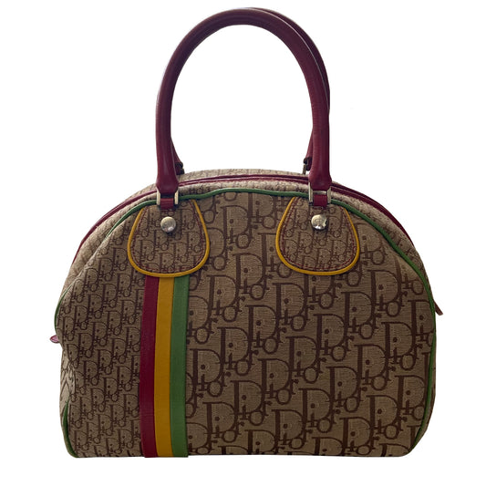 Christian Dior ad campaign Rasta Boston Bag by John Gallian for Dior. Beige and light brown Diorissimo canvas with silver-tone hardware, domed feet, 2 red leather rolled top handles, zipper pulls and end tab and red, yellow and green leather piping and tri-color leather front stripe. Made in Italy 