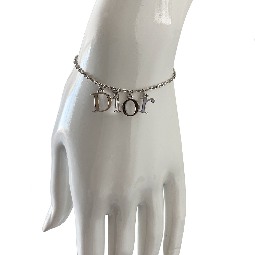 Christian Dior silver-tone charm bracelet with hanging letters that spell DIOR. Lobster back closure with 2 length adjustment loops and small hanging logo D charm.  Box included. 