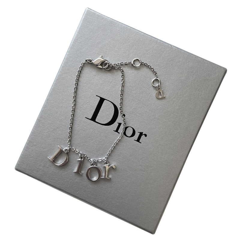 Christian Dior silver-tone charm bracelet with hanging letters that spell DIOR. Lobster back closure with 2 length adjustment loops and small hanging logo D charm.  Box included. 