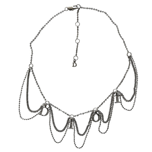 Christian Dior logo letters choker with 3 styles of draped chains and crystal embellished letters that spell Dior. Lobster back closure with 4 length adjustment loops and small hanging logo stamped D charm in back. 