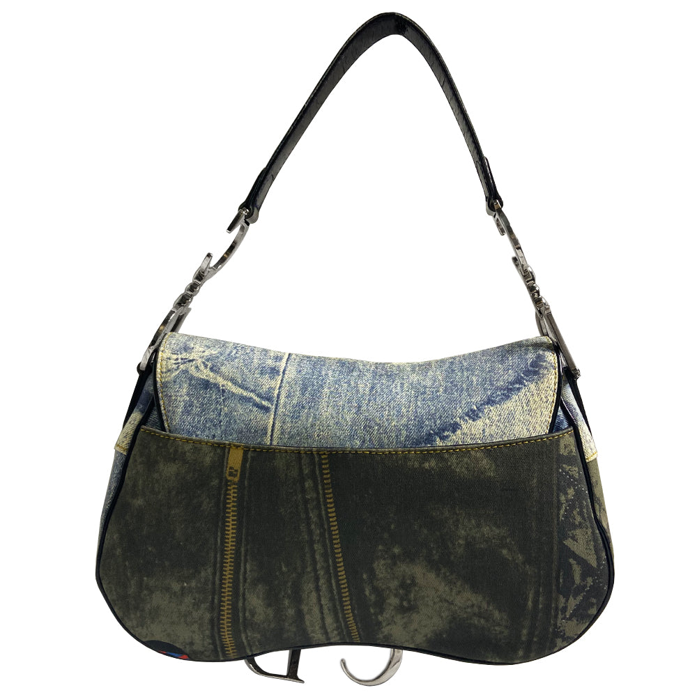 Christian Dior I Heart Sex denim saddle bag by John Galliano for Dior 2001. Trompe l’oeil blue and black denim with patch printed designs, black leather shoulder strap with silver-tone CD logo attachments, leather piping and hanging straps, silver-tone CD hanging logos. front flap, rear single slip pocket, interior zip pocket. Made in Italy 
