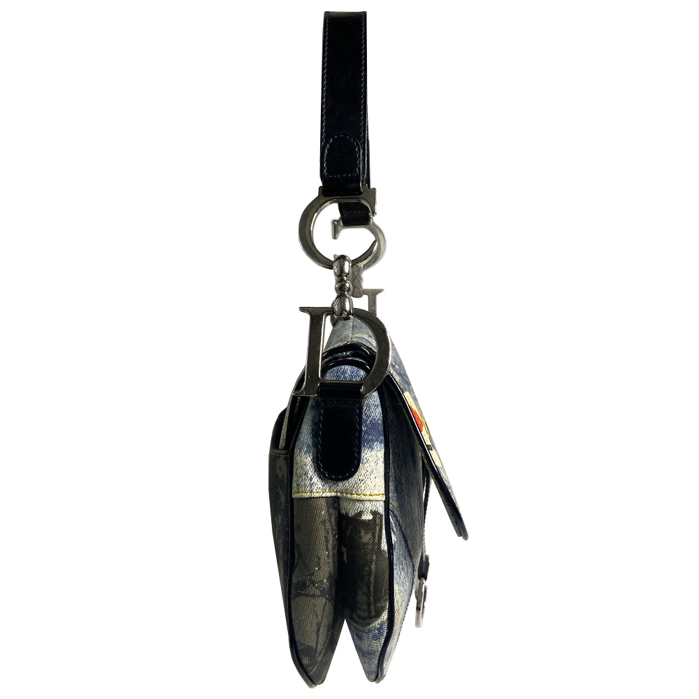 Christian Dior I Heart Sex denim saddle bag by John Galliano for Dior 2001. Trompe l’oeil blue and black denim with patch printed designs, black leather shoulder strap with silver-tone CD logo attachments, leather piping and hanging straps, silver-tone CD hanging logos. front flap, rear single slip pocket, interior zip pocket. Made in Italy 
