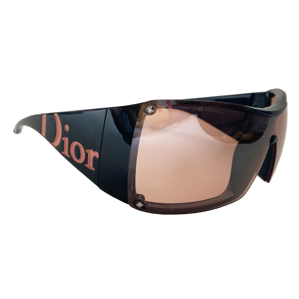 Christian Dior Overshine 2 Sunglasses circa early to mid 2000’s with oversized rose tint lenses, squared rims, black colored frame with wide arms. Dior logo name embossed in pink at each arm. Style: 00DX3 110. Made in Italy 