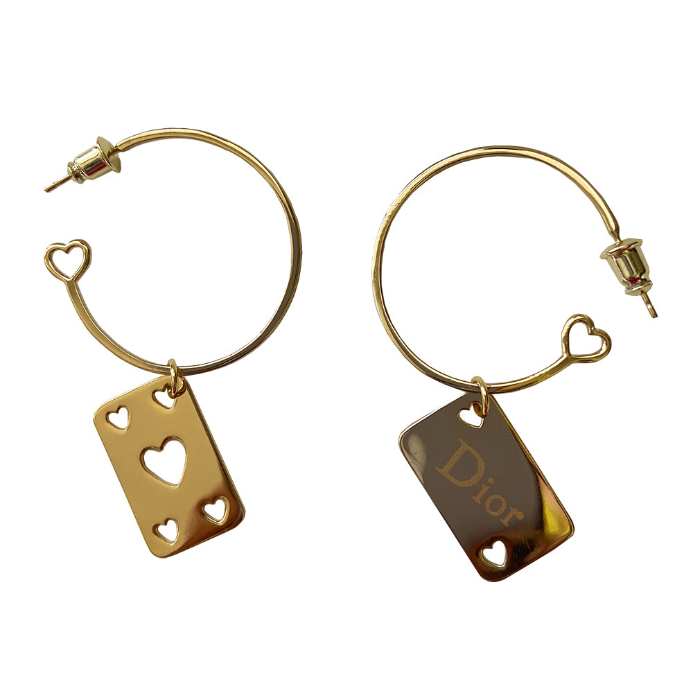 Christian Dior Earrings gold-tone metal hoop earrings with open heart design at one end, dangling heart cutout feature and etched Dior logo on playing cards. Clutch back closure. Missing the single hanging D charm 