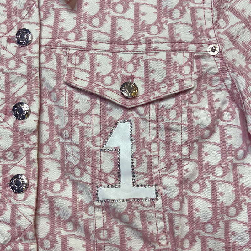 Christian Dior pink monogram Girly button up denim jacket by John Galliano for Dior, spring 2004 with 2 front flap pockets at chest and No 1 surrounded by Swarovski crystals. Silver-tone logo buttons and engraved logo buckle details on adjustable side straps, Dior crystal logo at one sleeve cuff. Made in Portugal 