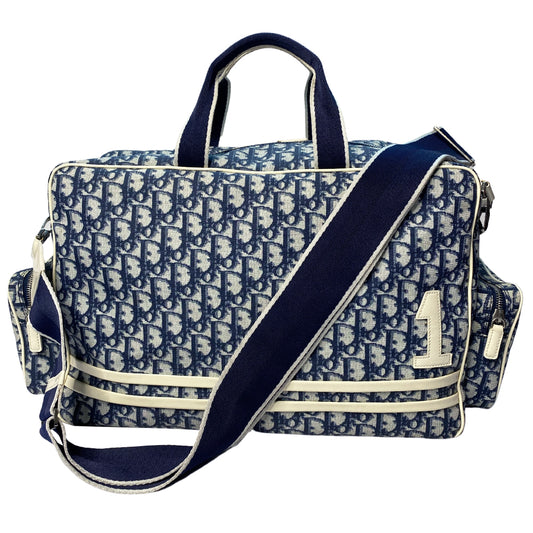 John Galliano for Dior, 2002 navy monogram canvas large weekender bag with 2 outer zip end pouches, velcro rear pocket, white patent leather piping, zipper pulls, No 1 appliqué in front and 2 accent stripes in front. Double canvas handles, detachable, adjustable navy carry strap. Silver-tone zipper and hardware, navy nylon lining with zippered pocket, two snap slip pockets, 3 open pouch pockets. Made in Italy 