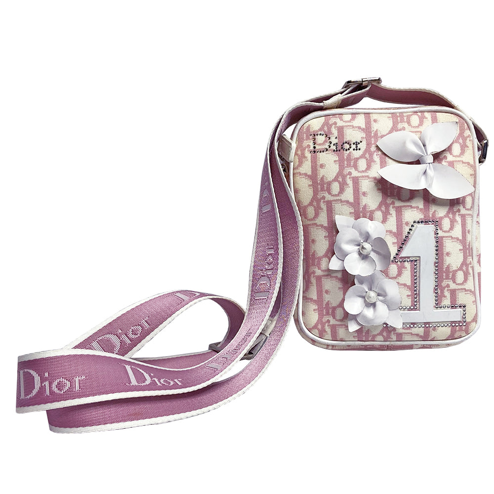 Christian Dior Girly pink monogram cross body reporter bag by John Galliano for Dior 2004 with pearl center white flowers, white piping, Swarovski crystal No 1 & Dior logo. Pink satin webbing adjustable shoulder strap with silver-tone Dior engraved sliders. Pink textile interior, one inner pocket. Made in Italy