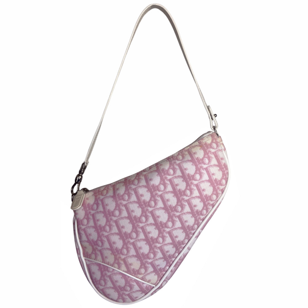 Christian Dior pink canvas monogram mini saddle pochette by John Galliano for Dior 2004 with white patent leather piping and strap, silver-tone hardware. Leather strap unclips at one end and can be looped to carry wristlet style. Top zipper closure with  pink textile interior. Duster and card included. Made in Spain 