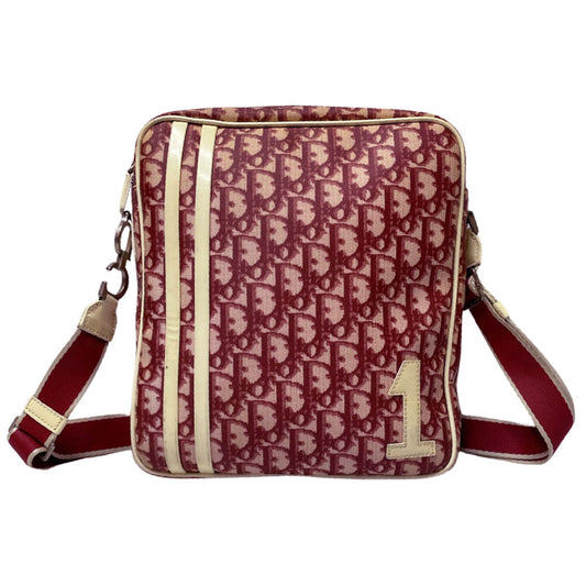 Christian Dior red monogram canvas slim reporter bag by John Galliano for Dior 2004 with white patent No 1 and 2 stripes in front, piping and accents, red with white edged satin canvas webbing adjustable shoulder strap. Top zip closure with red textile interior and one interior zip pocket. Made in Italy 