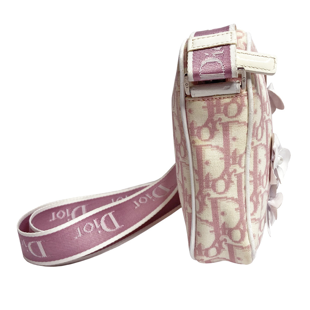 Christian Dior Girly pink monogram cross body reporter bag by John Galliano for Dior 2004 with pearl center white flowers, white piping, Swarovski crystal No 1 & Dior logo. Pink satin webbing adjustable shoulder strap with silver-tone Dior engraved sliders. Pink textile interior, one inner pocket. Made in Italy