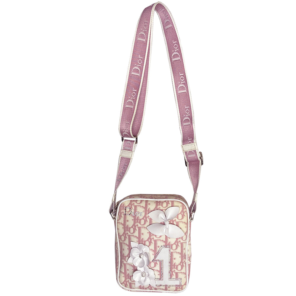 Christian Dior Girly pink monogram cross body reporter bag by John Galliano for Dior 2004 with pearl center white flowers, white piping, Swarovski crystal No 1 & Dior logo. Pink satin webbing adjustable shoulder strap with silver-tone Dior engraved sliders. Pink textile interior, one inner pocket. Made in Italy