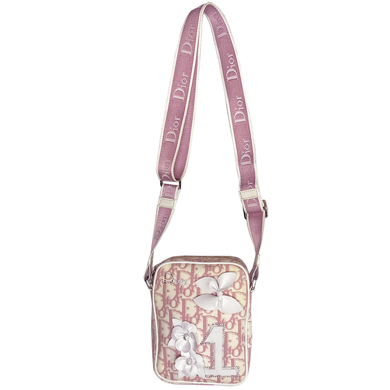 Christian Dior Girly pink monogram cross body reporter bag by John Galliano for Dior 2004 with pearl center white flowers, white piping, Swarovski crystal No 1 & Dior logo. Pink satin webbing adjustable shoulder strap with silver-tone Dior engraved sliders. Pink textile interior, one inner pocket. Made in Italy