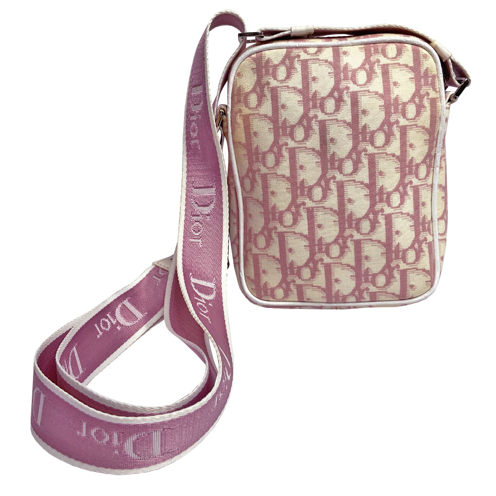 Christian Dior Girly pink monogram cross body reporter bag by John Galliano for Dior 2004 with pearl center white flowers, white piping, Swarovski crystal No 1 & Dior logo. Pink satin webbing adjustable shoulder strap with silver-tone Dior engraved sliders. Pink textile interior, one inner pocket. Made in Italy