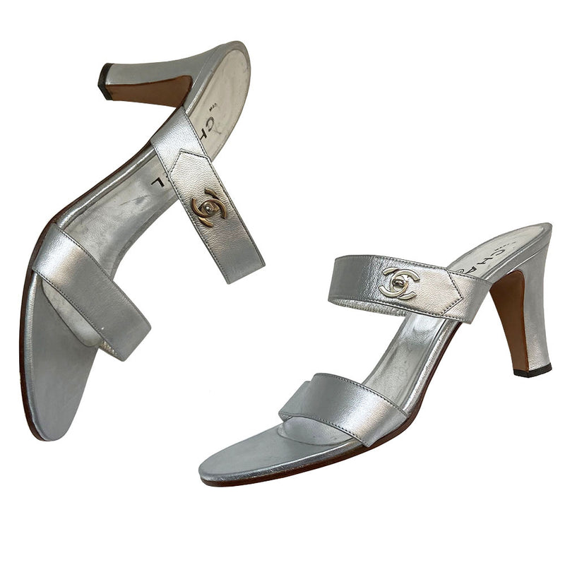 Chanel silver metallic leather open-toe heeled sandals, slip on style with 2 strap upper with silver-tone signature Chanel Mademoiselle turn-lock CC logo embellishment on one strap. Leather interior and soles. Almost no wear at soles Size: IT 39 Made in Italy 
