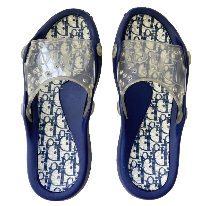 Christian Dior monogram navy on white blue jelly slides sandals from John Galliano early 2000’s era. Dior logo embossed clear upper with perforated air holes. Monogram insole with clear nubby overlay. Rubber bottom sole with Dior logo imprint. Original clear plastic Diorissimo print storage bag included. Made in Italy 