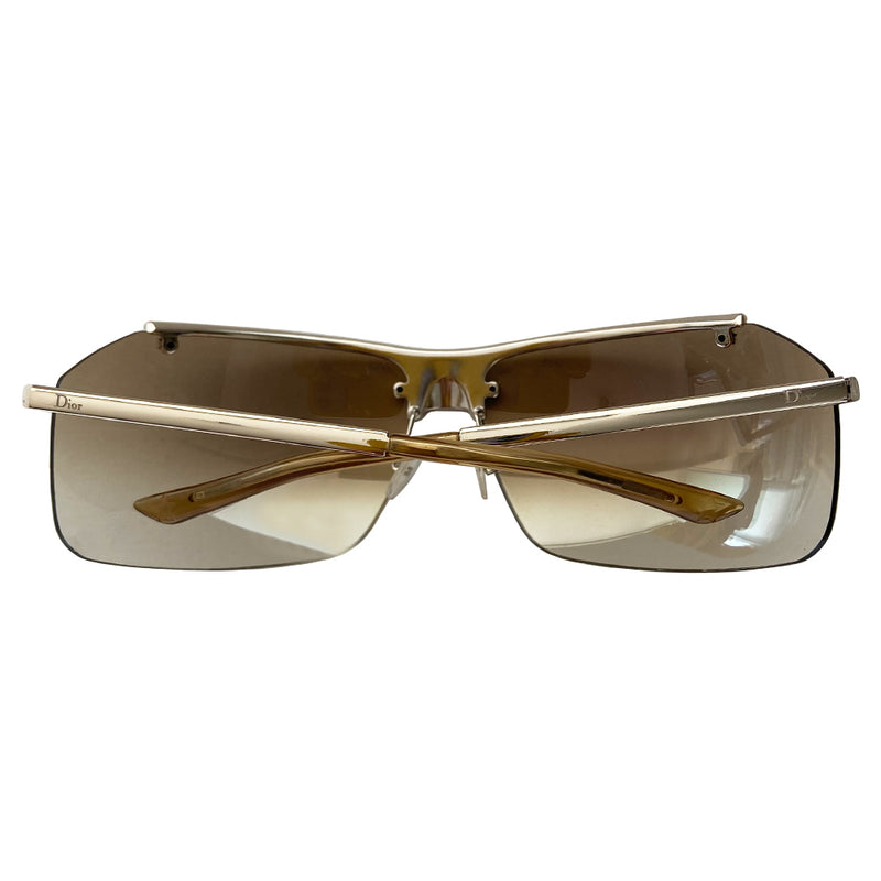 Christian Dior HIT 2 frameless sunglasses with curved charcoal color lens and logo engraved silver-tone metal bridge, crystal embellished upper frame edge, Dior engraved arms, and nose bridge. Made in Italy. 