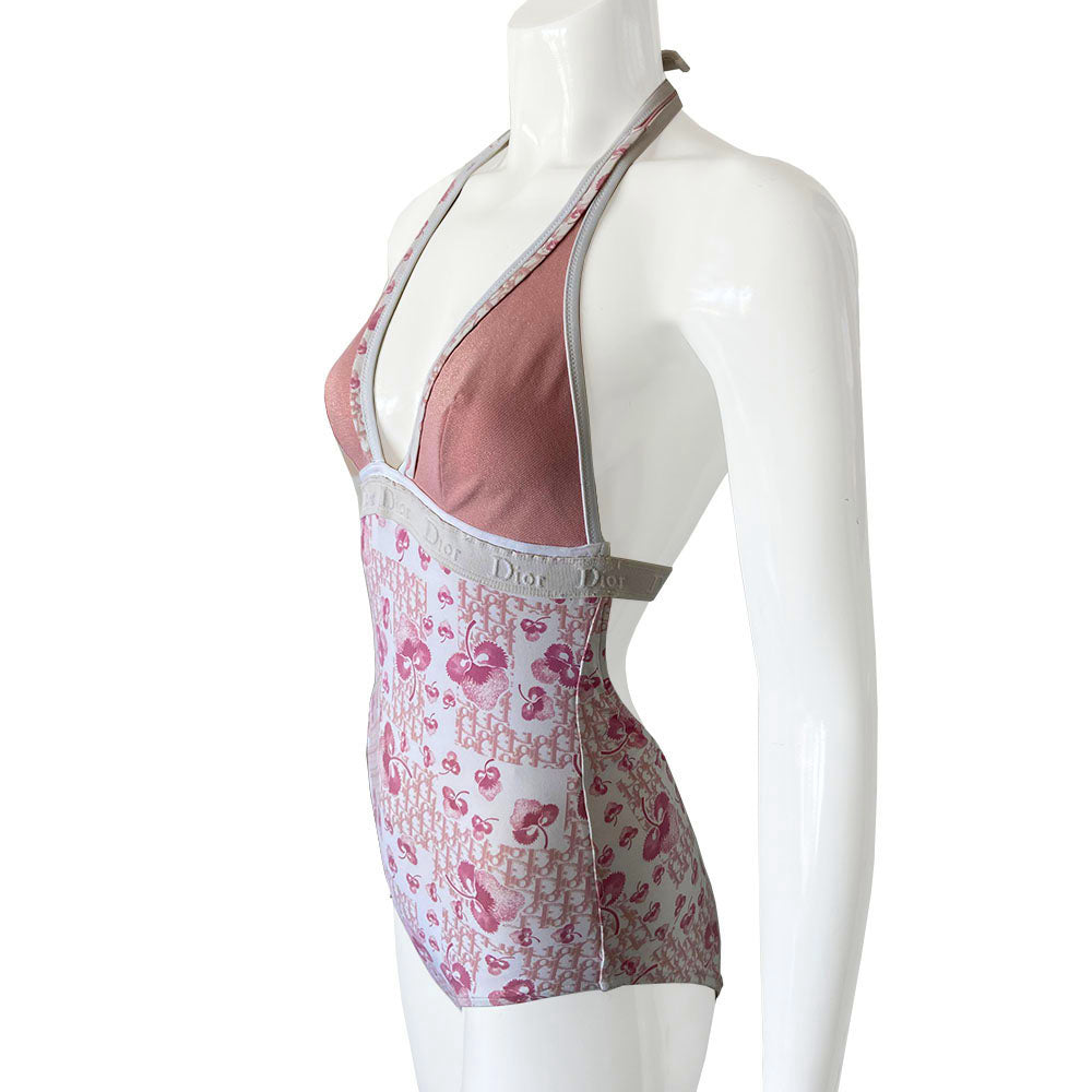 Christian Dior cherry blossom one-piece swimsuit by John Galliano for Dior from 2004 Logo Flowers Collection. Halter style tie neck, deep V neckline and low back. Solid pink upper and cherry blossom monogram lower divided by Dior Logo wide elastic under the bust line and across the back. Size: FR 40. Made in Italy 